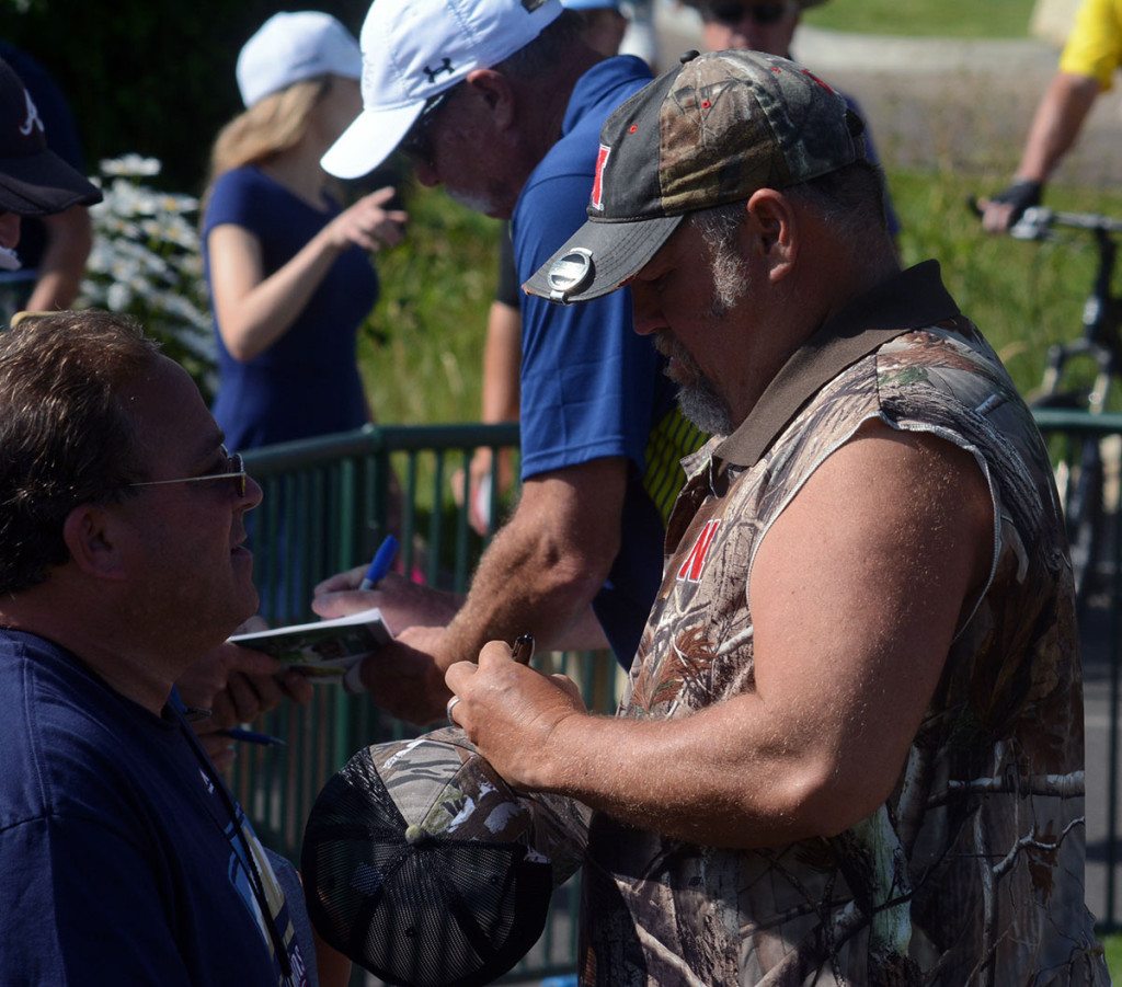 Larry the Cable Guy signs a hat for a fan with the same sense for fashion.