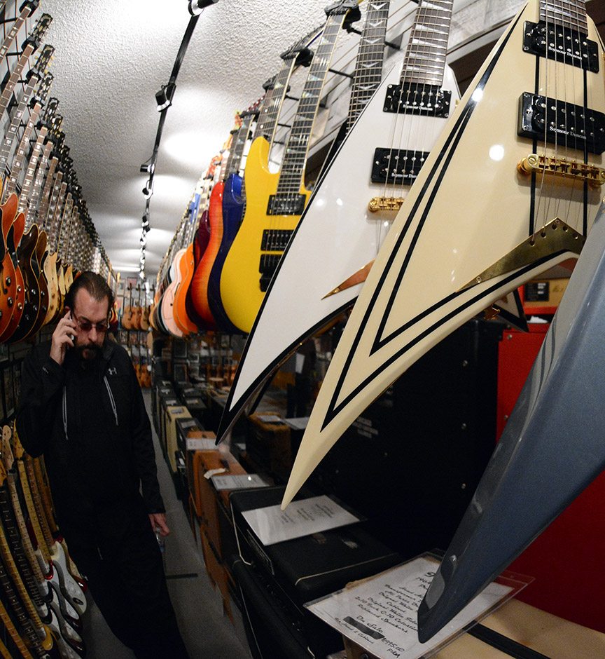 Greg Golden takes a call on  the Flying V aisle in the vault at Bizarre Guitar in north Reno. Tim Parsons/ Tahoe Onstage